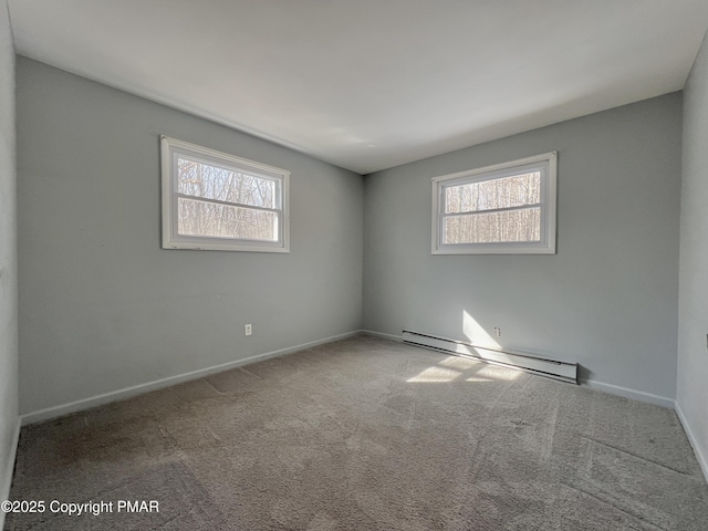 carpeted empty room featuring a baseboard heating unit and a wealth of natural light