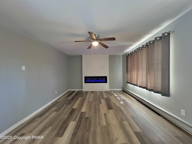 unfurnished living room with hardwood / wood-style flooring, a baseboard radiator, a large fireplace, and ceiling fan