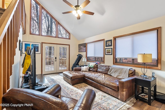 living area with ceiling fan, high vaulted ceiling, wood finished floors, and french doors