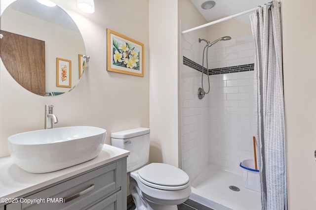 bathroom featuring a stall shower, vanity, and toilet