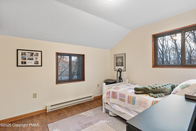 bedroom with lofted ceiling, baseboards, a baseboard heating unit, and wood finished floors