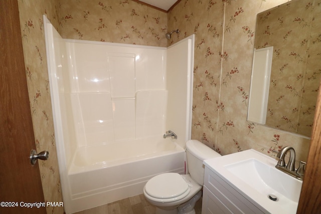 full bath with  shower combination, vanity, toilet, and wallpapered walls