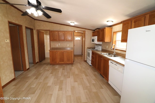 kitchen featuring light wood-type flooring, lofted ceiling, white appliances, and a sink