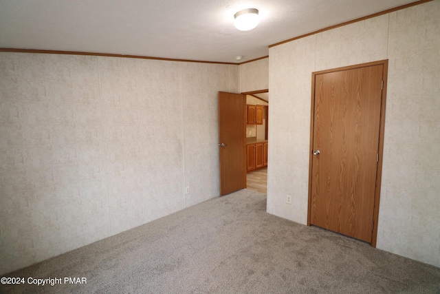 unfurnished room with carpet floors and crown molding