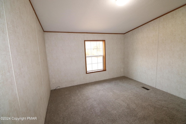 empty room featuring ornamental molding, carpet flooring, and visible vents