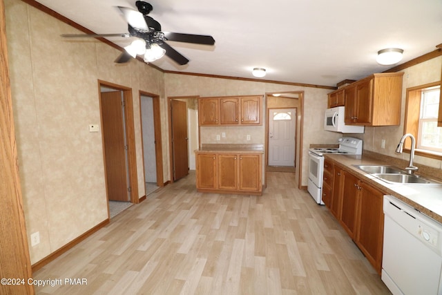 kitchen featuring white appliances, light wood-style floors, vaulted ceiling, and a sink