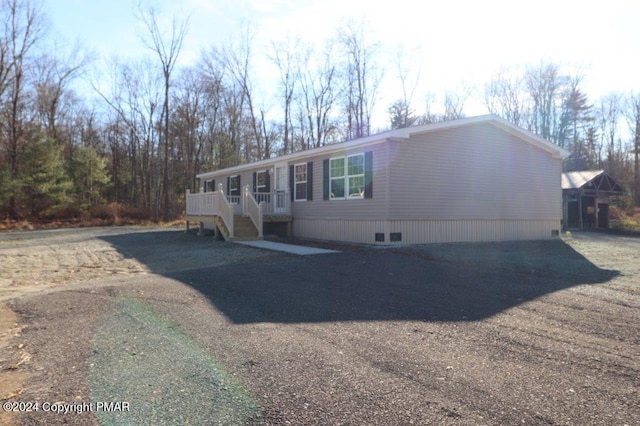 manufactured / mobile home featuring dirt driveway and a wooden deck