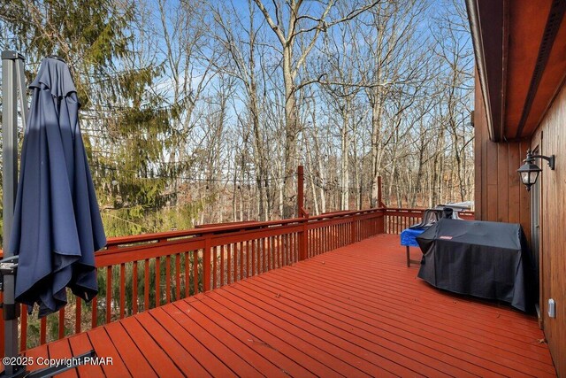 snow covered house featuring a wooden deck and a patio area