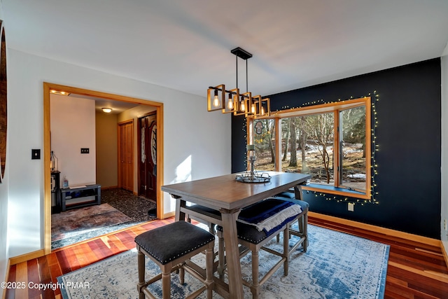 dining area with hardwood / wood-style flooring and a chandelier