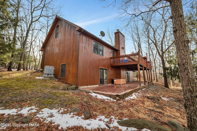 back of property featuring a deck and a chimney