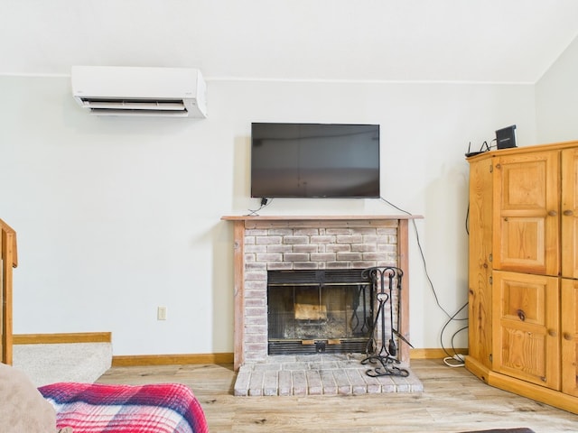 living room featuring a fireplace, a wall unit AC, wood finished floors, and baseboards