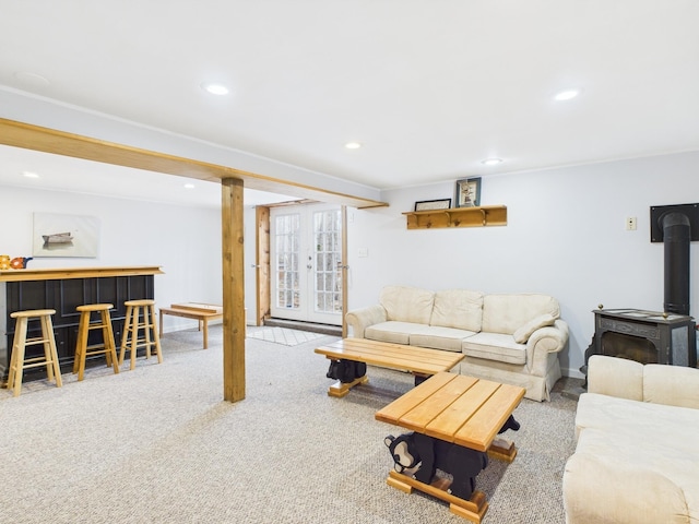 carpeted living room featuring recessed lighting, a wood stove, french doors, and a bar