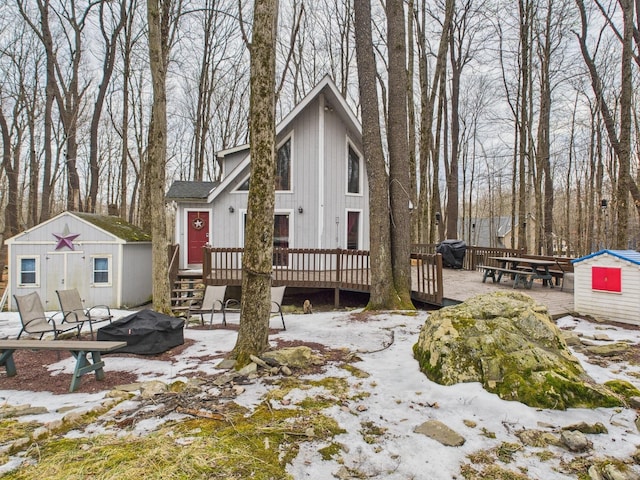 view of front of house with a storage shed, a deck, and an outdoor structure