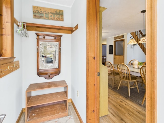 staircase featuring wood finished floors and baseboards