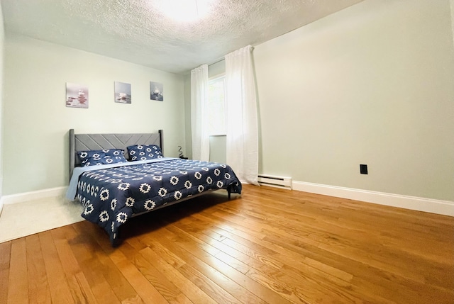 8540 Hillcrest Dr, Tobyhanna, PA 18466 - bedroom with wood-type flooring, a textured ceiling, and baseboard heating