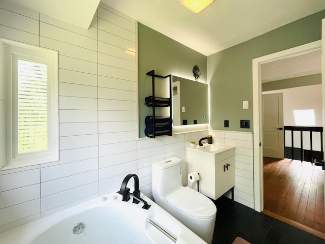 8540 Hillcrest Dr, Tobyhanna, PA 18466 - bathroom with tile walls, a tub with jets, vanity, and a wainscoted wall
