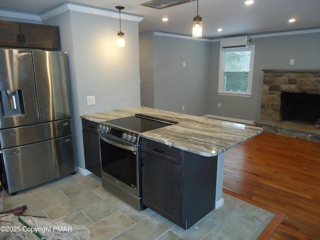 kitchen featuring a stone fireplace, hanging light fixtures, stainless steel appliances, crown molding, and light stone countertops