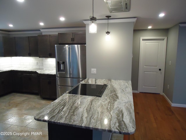 kitchen with decorative backsplash, hanging light fixtures, stainless steel fridge with ice dispenser, light stone countertops, and dark brown cabinets