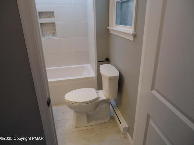 bathroom featuring toilet, hardwood / wood-style floors, and a baseboard heating unit