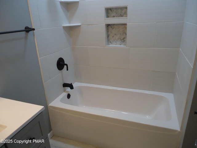 bathroom with tiled shower / bath combo and vanity