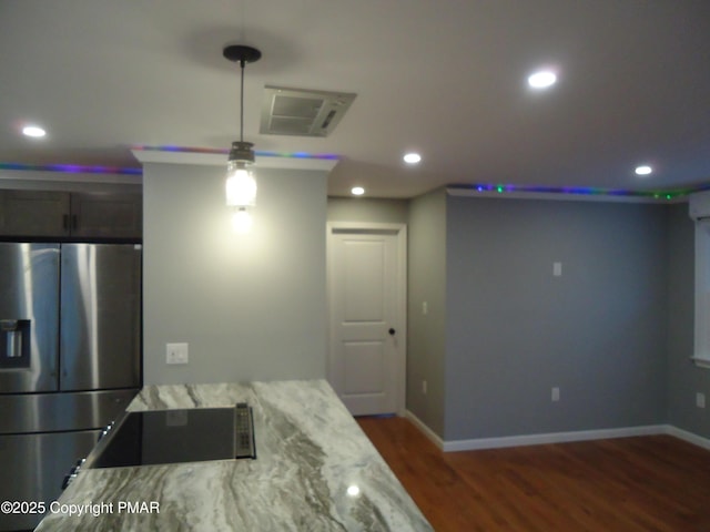 kitchen featuring light stone counters, an AC wall unit, stainless steel fridge, dark hardwood / wood-style flooring, and black electric stovetop