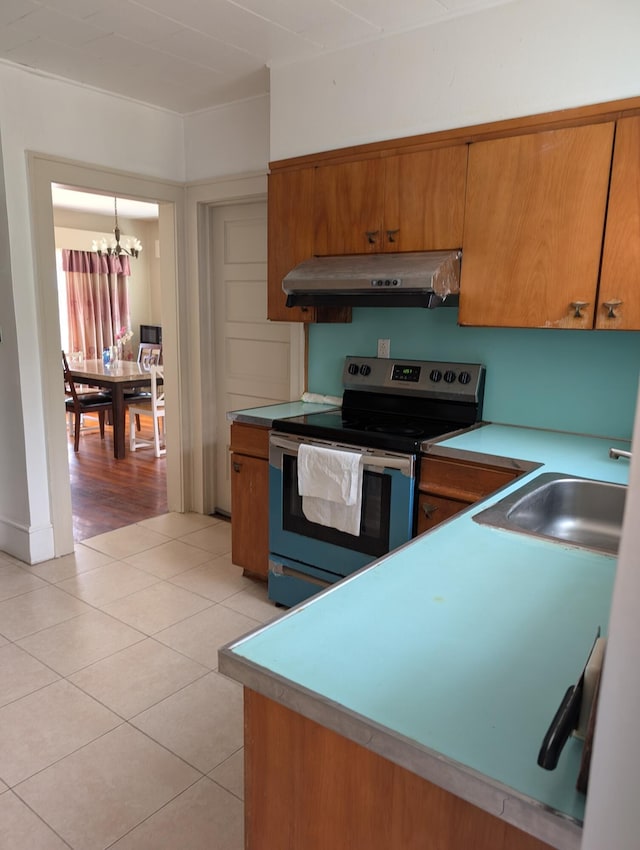1105 Rte 390, Cresco, PA 18326 - kitchen with stainless steel electric range oven, range hood, brown cabinetry, and a chandelier