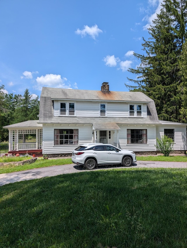 1105 Rte 390, Cresco, PA 18326 - colonial inspired home featuring a front lawn, a chimney, and a gambrel roof
