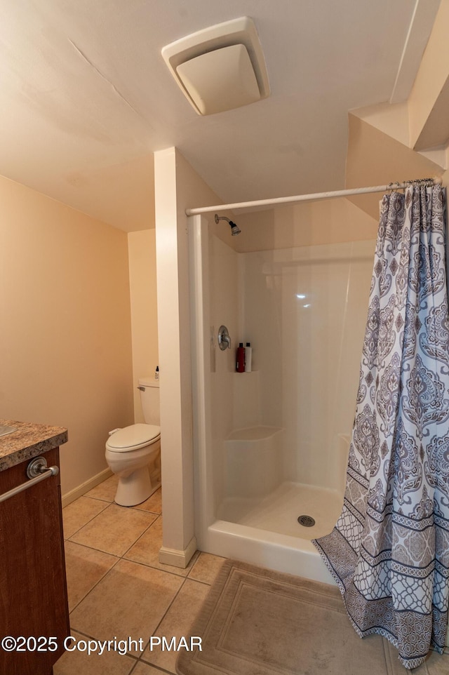 bathroom with toilet, tile patterned flooring, and curtained shower