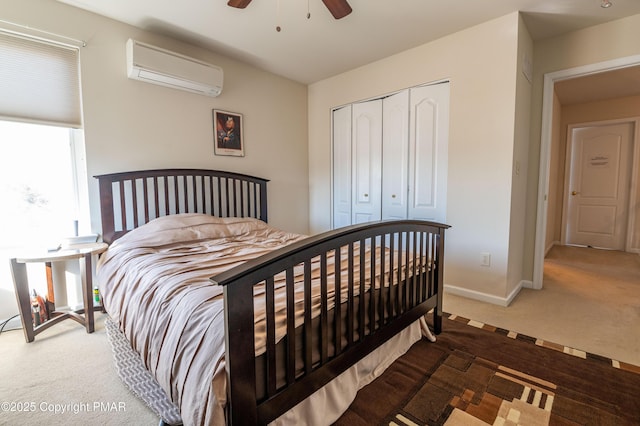 bedroom with ceiling fan, a wall unit AC, carpet, and a closet