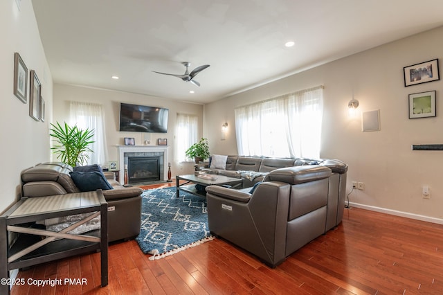 living room with ceiling fan, dark hardwood / wood-style flooring, and a fireplace