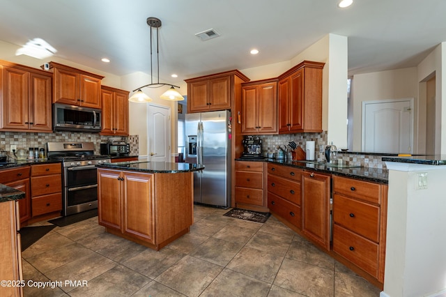 kitchen featuring stainless steel appliances, pendant lighting, a center island, backsplash, and kitchen peninsula