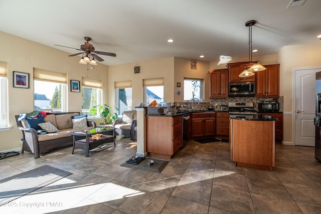 kitchen with sink, decorative light fixtures, stainless steel appliances, kitchen peninsula, and decorative backsplash