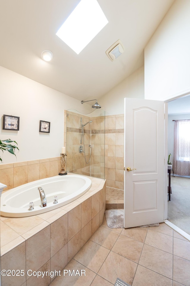 bathroom with tile patterned floors, independent shower and bath, and vaulted ceiling with skylight