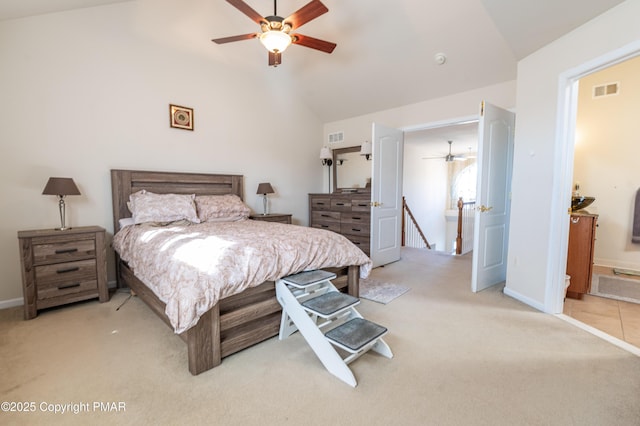 carpeted bedroom featuring lofted ceiling, ceiling fan, and ensuite bath