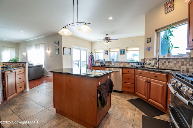 kitchen with dishwasher, a kitchen island, decorative light fixtures, range, and tasteful backsplash