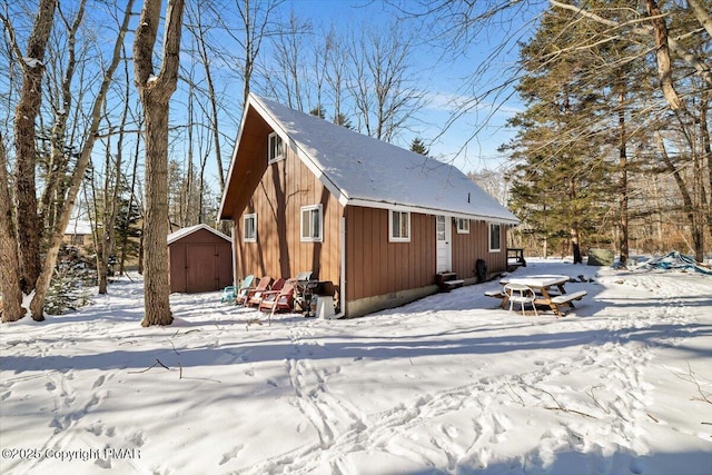 exterior space featuring a shed, a detached garage, and an outbuilding