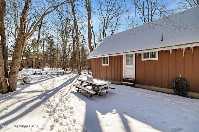 exterior space featuring entry steps, outdoor dining space, and board and batten siding