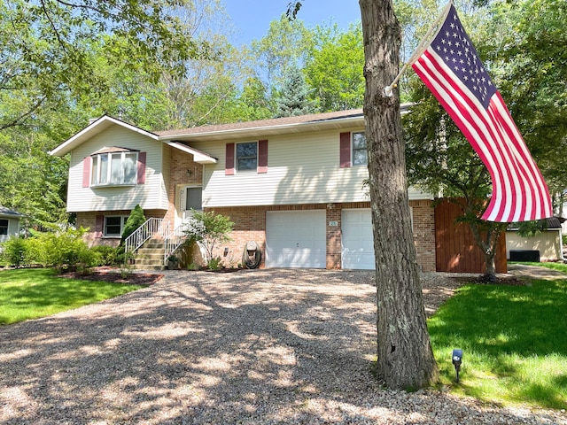 25 Cobblewood Dr, Mount Pocono, PA 18344 - raised ranch featuring brick siding, gravel driveway, an attached garage, and a front lawn