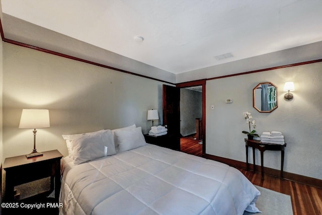 bedroom featuring baseboards and wood finished floors