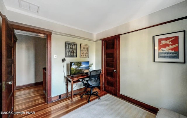 office space featuring visible vents, baseboards, and wood finished floors