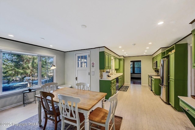 dining area with light wood-style floors, recessed lighting, crown molding, and baseboards