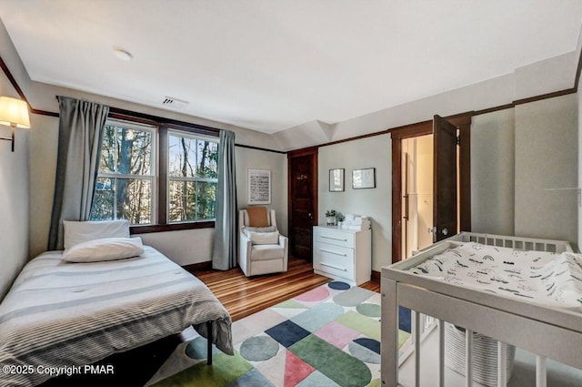 bedroom with visible vents and wood finished floors