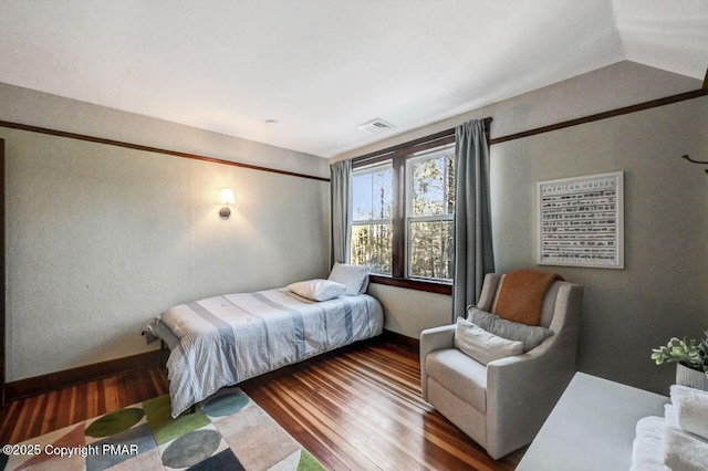 bedroom featuring wood finished floors and visible vents