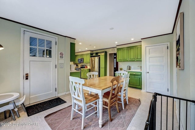 dining room featuring baseboards, crown molding, and recessed lighting