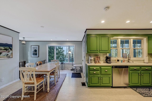 kitchen featuring stainless steel dishwasher, light countertops, light wood-style floors, green cabinets, and a sink