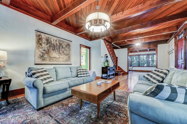 living area with a notable chandelier, wood finished floors, wood ceiling, stairway, and beamed ceiling