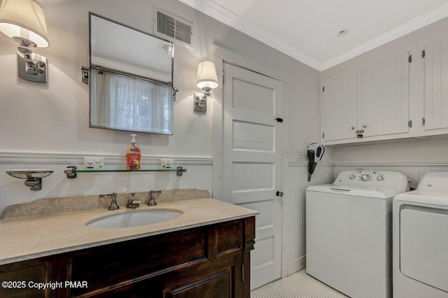 bathroom with visible vents, toilet, ornamental molding, washing machine and clothes dryer, and vanity