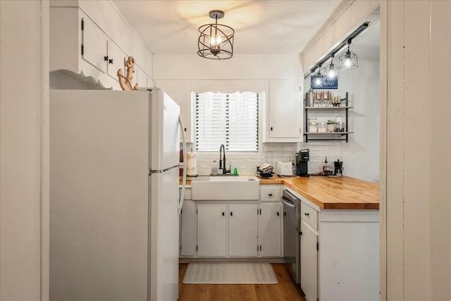 62 Locust Ln, Gouldsboro, PA 18424 - kitchen with dishwasher, butcher block counters, tasteful backsplash, a sink, and freestanding refrigerator