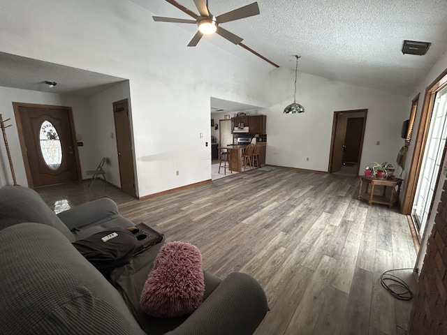 living area with light wood-type flooring, baseboards, a textured ceiling, and ceiling fan