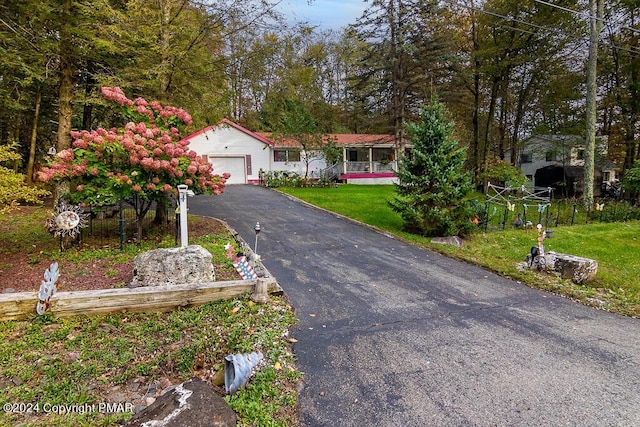 view of front of property with a front lawn, a garage, and driveway